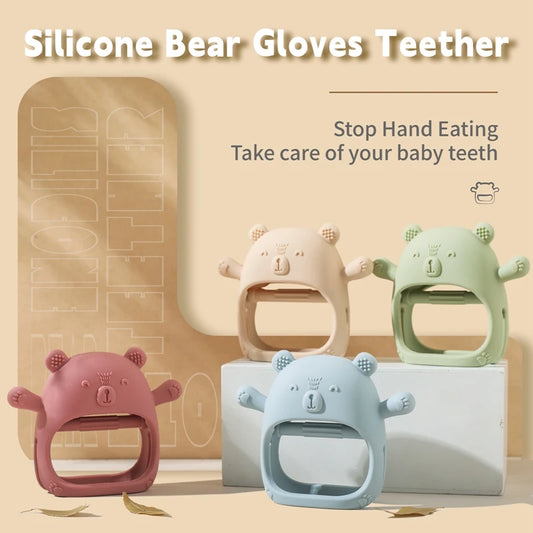 Silicone bear gloves teether in pink, blue, and green with a beige background.