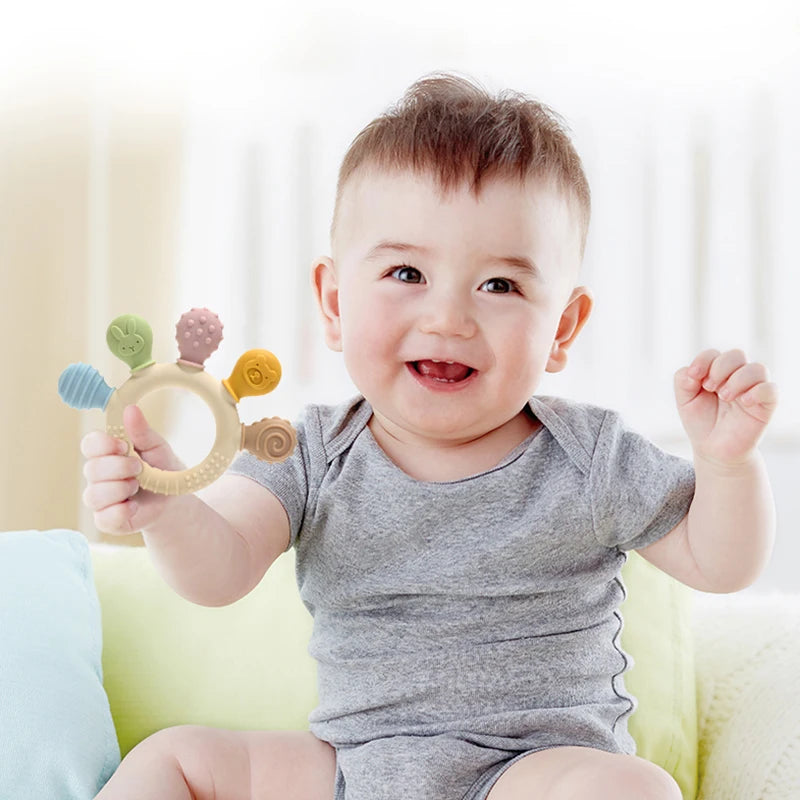 Baby holding a colorful toy with a blurred background