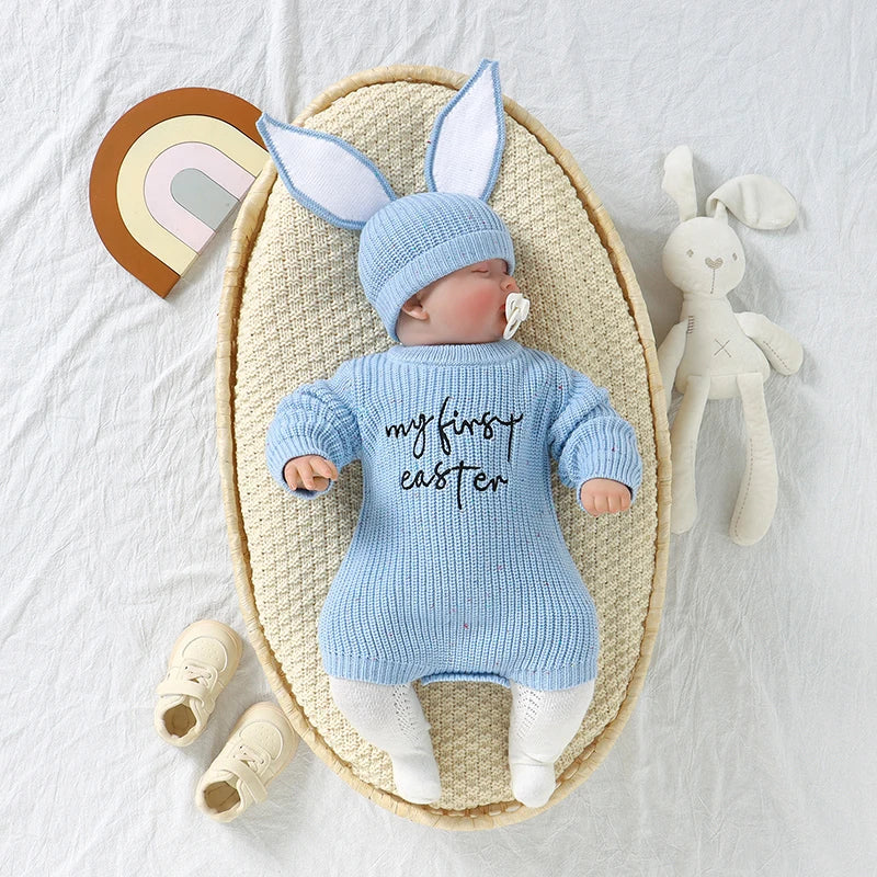 Baby in blue Easter outfit with bunny ears and 'my first Easter' shirt, surrounded by Easter-themed items on a light background.