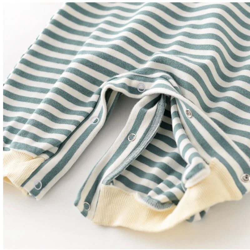 Striped baby outfit with green and white stripes on a light background