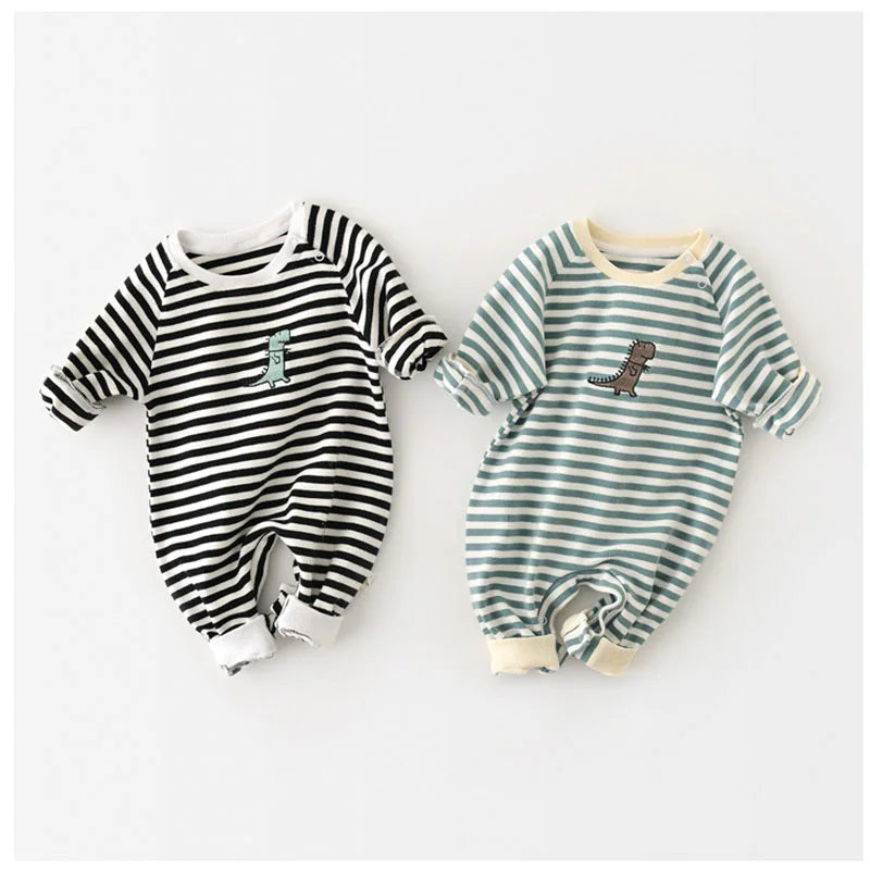 Two baby rompers, one black and white striped and the other green and white striped, on a light gray background.