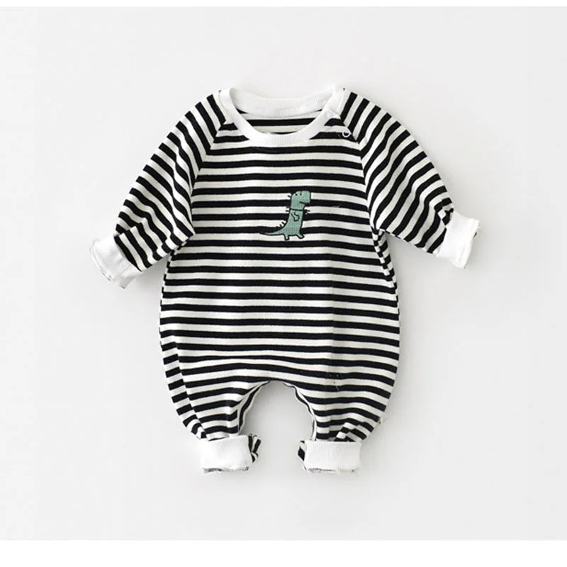 Black and white striped baby romper with a small green dinosaur design on a light gray background