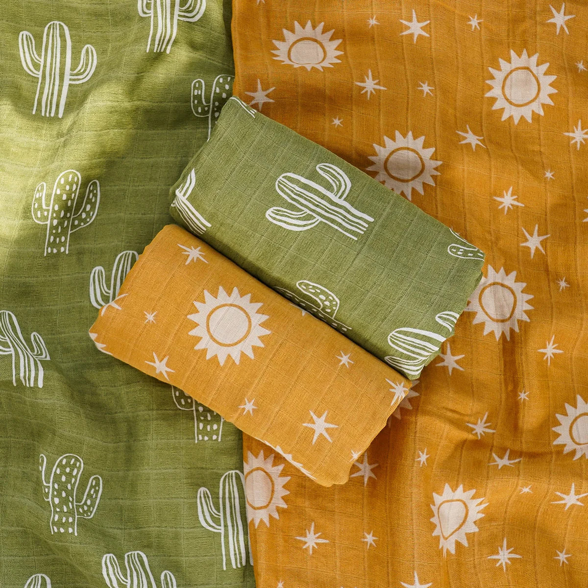 Two folded fabric swatches with cactus and sun patterns on a green and orange background.
