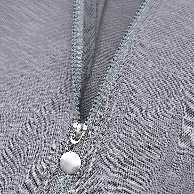Close-up of a silver zipper on a gray fabric background