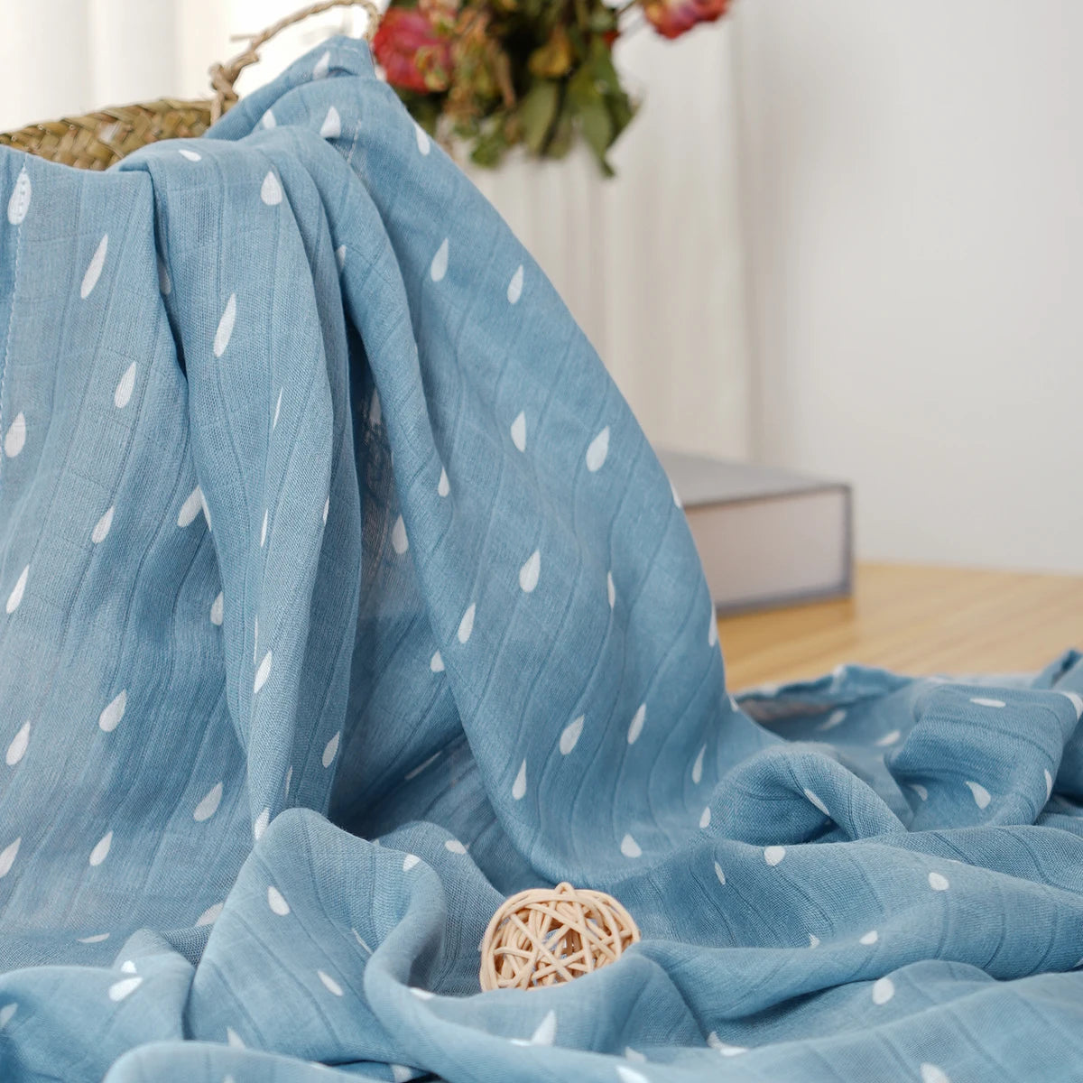 Blue fabric with white patterns draped over a surface, with a blurred indoor background.