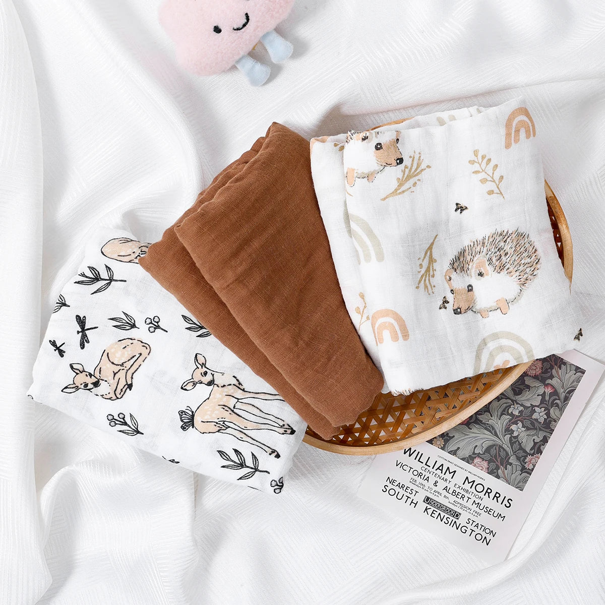 Folded baby blankets with animal prints on a white surface